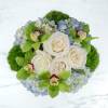 A blue and green arrangement in a stylish silver vase, this arrangement