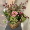 Mixed seasonal blooms in a wooden rustic vase