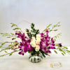 Lavender Elegance, roses and orchids arranged in a vase.