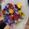 Cheerful bright mix of roses and other flowers in hand tied bouquet