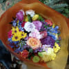 Cheerful bright mix of roses and other flowers in hand tied bouquet