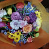 Cheerful bright mix of roses and other flowers in hand tied bouquet