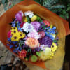 Cheerful bright mix of roses and other flowers in hand tied bouquet
