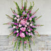 
Pink roses, lilies, and more come together for a blushing pink standing