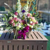 A custom desogn with lavender Roses, Carnations, Lilies, white Delphinium, Orchids, burgundy