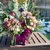 A custom desogn with lavender Roses, Carnations, Lilies, white Delphinium, Orchids, burgundy