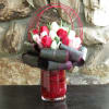 Tulips arranged in a glass vase with tropical leaves