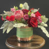 A compact design with tropical blooms like protea, pin cushion, or ginger.