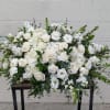 A lovely casket spray in all white flowers.