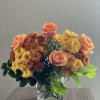 Vibrant floral arrangement of orange roses, yellow and bronze chrysanthemum flowers with