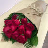 Beautiful bouquet of fresh roses wrapped in paper for the convenience of