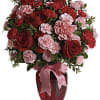 A mix of carnations and roses in shades of red and light