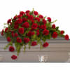 This classic half-couch spray of brilliant red carnations makes a striking and