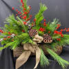 winter centerpiece made up of seasonal greens Berries, and pods. 