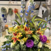 Delphinium, seasonal lilies, dahlias, and lisianthus in a low dish. 