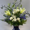 This blue vase is filled with white and blue blooms! 
White lilies