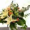 Made with roses, lilies, stocks, and greenery.