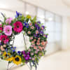 Whimsical, bright, naturally designed standing wreath. 