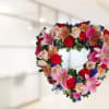 Heart shaped memorial wreath, designed with assorted femanine colors including pink, peach