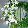 This sympathy standing wreath, in white and green, is a stunning symbol