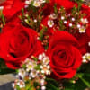 A mix of seasonal red flowers in a glass vase.
