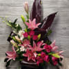 Lilies, Spray Roses, Orchids, Variety of Greens, and Filler.