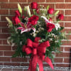 A DOZEN RED ROSES BEAUTIFULLY ARRANGED WITH STARGAZER LILIES.