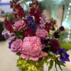 Tall vase arrangement with bold reds and pinks, made with snapdragons, peony