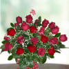 Two Dozen Red (24) roses with greenery in clear glass vase.