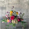 Lush garden style blooms arranged in compote style vessel