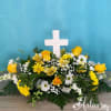  A ceramic cross rises from a field of roses and daisies.