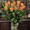 Enjoy a dozen premium quality long stem orange roses professionally arranged with