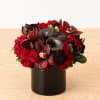 A sensual combination of red roses, burgundy orchids, aubergine scabiosa, and black