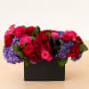 A bed of purple hydrangea in a sleek black ceramic rectangle vase