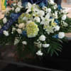 Blue and white casket spray filled with blue/white carnations, hydrangeas, white lillies