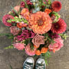 Monochromatic oranges in a clear glass vase with ti leaf 