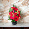 Arrangement with red Gerberas, hot pink roses in black vase .