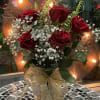 Red roses beautifully arranged in a glass vase with a beautiful ribbon