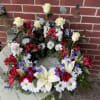 Our patriotic sympathy wreath is designed with a fresh assortment of red
