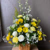 Bright yellow and white florals fill a basket. A wonderful arrangement for