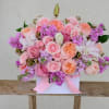 Different shade of pink flowers are carefully arranged inside the flower box.