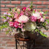 composed of white hydrangea , wax flower, tulips, snap dragons, lisianthus, peonies