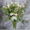 A dozen white roses perfectly arranged and complimented by quality fillers in