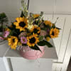 Complementing the sunflowers are various filler flowers and greenery, such as delicate