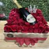 a wood box with 65 red roses with wine and a crown