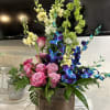 The bouquet is dominated by eye-catching blue and white dyed orchids, their