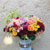 Beautiful pink, maroon, yellow arrangment with roses, orchids, tropical, berries, and green