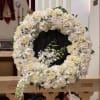 Medium sized circle sympathy arrangement with reef made with roses hydrangeas and