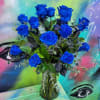 An arrangement in a clear vase with blue roses and greenery.

There is
