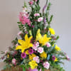 Pinks and yellows sympathy flowers make a grand statement in this joyful
